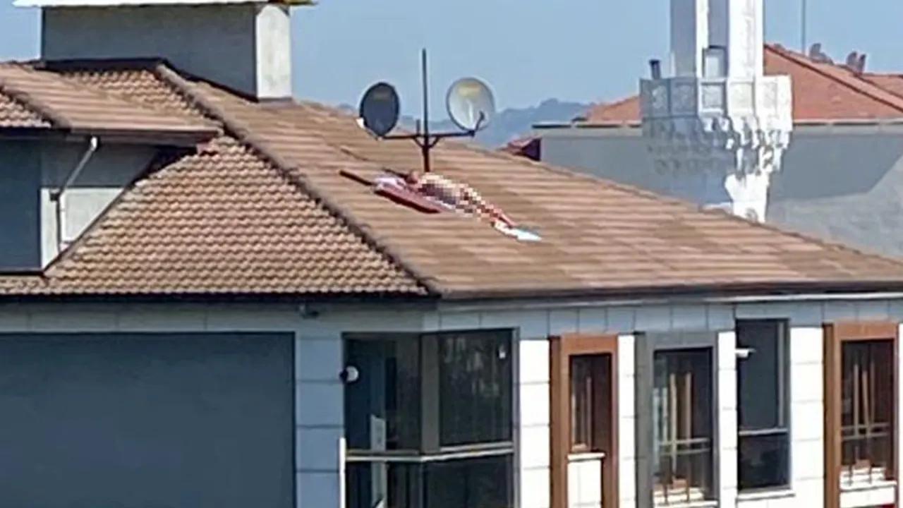 Çatıda çıplak halde güneşlendi, polis sirenini duyunca kaçtı