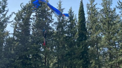 Gösteri uçuşu yapan paraşüt pilotu ağaçlara takıldı