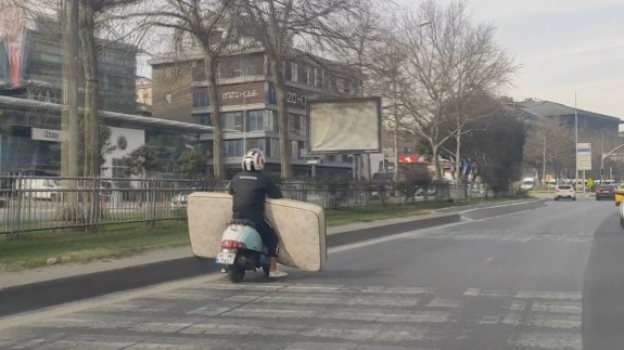 Trafikte tehlikeli yolculuk: Motosikletle yatak taşıdı